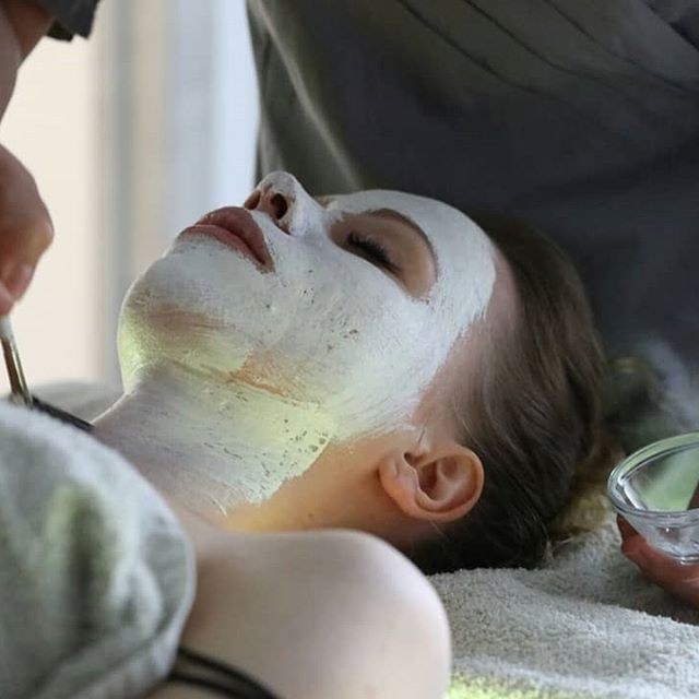 Una cliente con una maschera bianca sul viso, distesa in cabina
